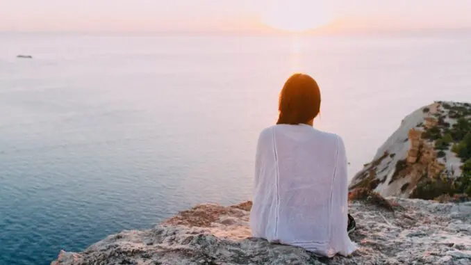 woman sitting by water worried about death anxiety