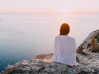 woman sitting by water worried about death anxiety
