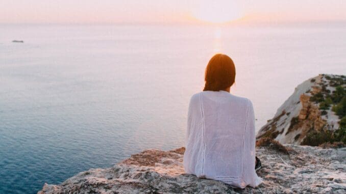 woman sitting by water worried about death anxiety