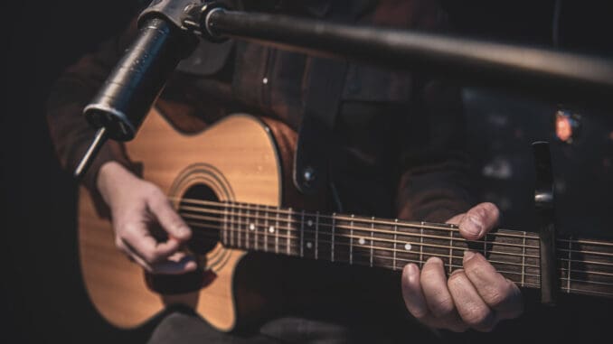 man playing guitar talking about Chicago, the Blues and Mental Health